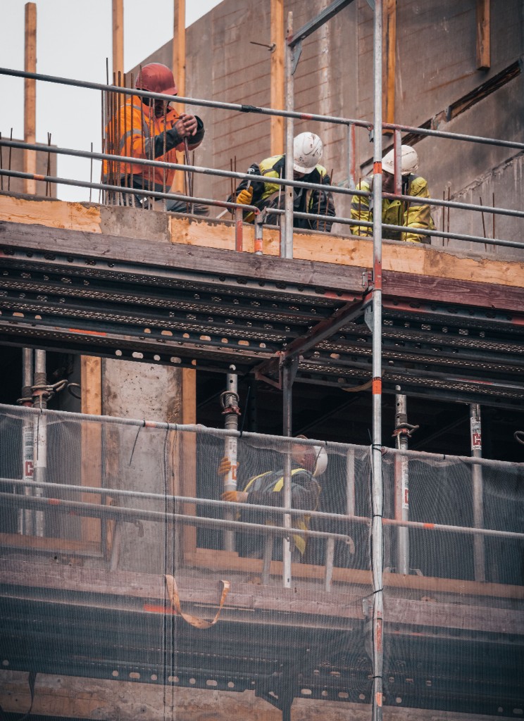 Engineers inspecting scaffolding and concrete structure on site
