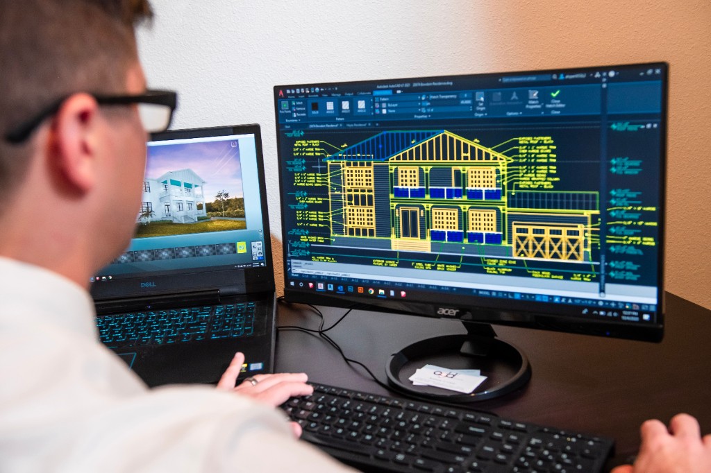 Engineer working on AutoCAD structural drawings and 3D model